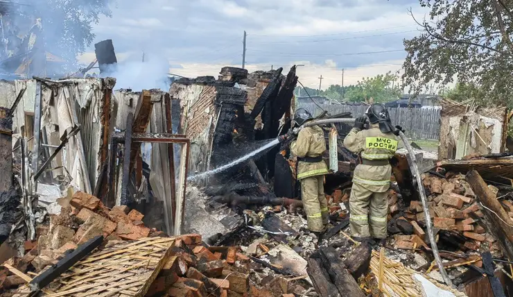В поселке Козулька пожарные с трех часов ночи пытаются потушить заброшенную постройку