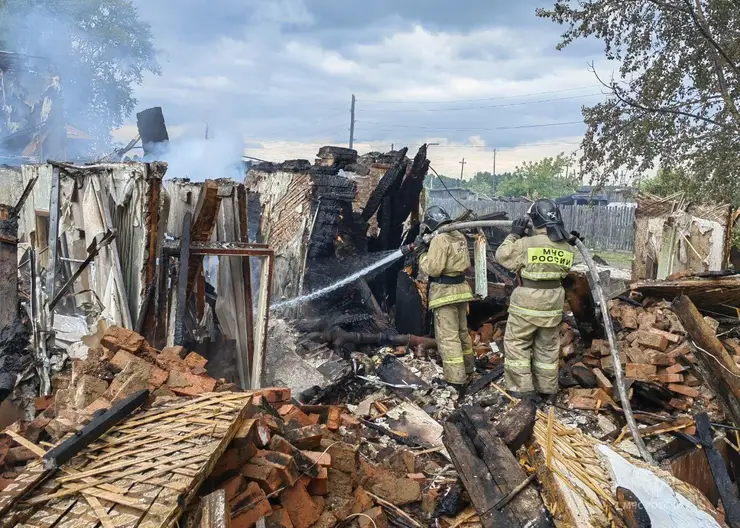 В поселке Козулька пожарные с трех часов ночи пытаются потушить заброшенную постройку