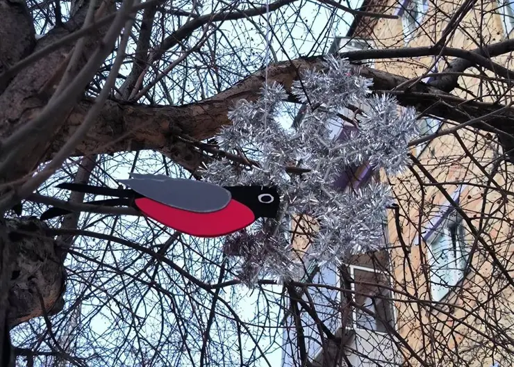 В Красноярске на улице Сурикова появились снежинки и снегири на деревьях