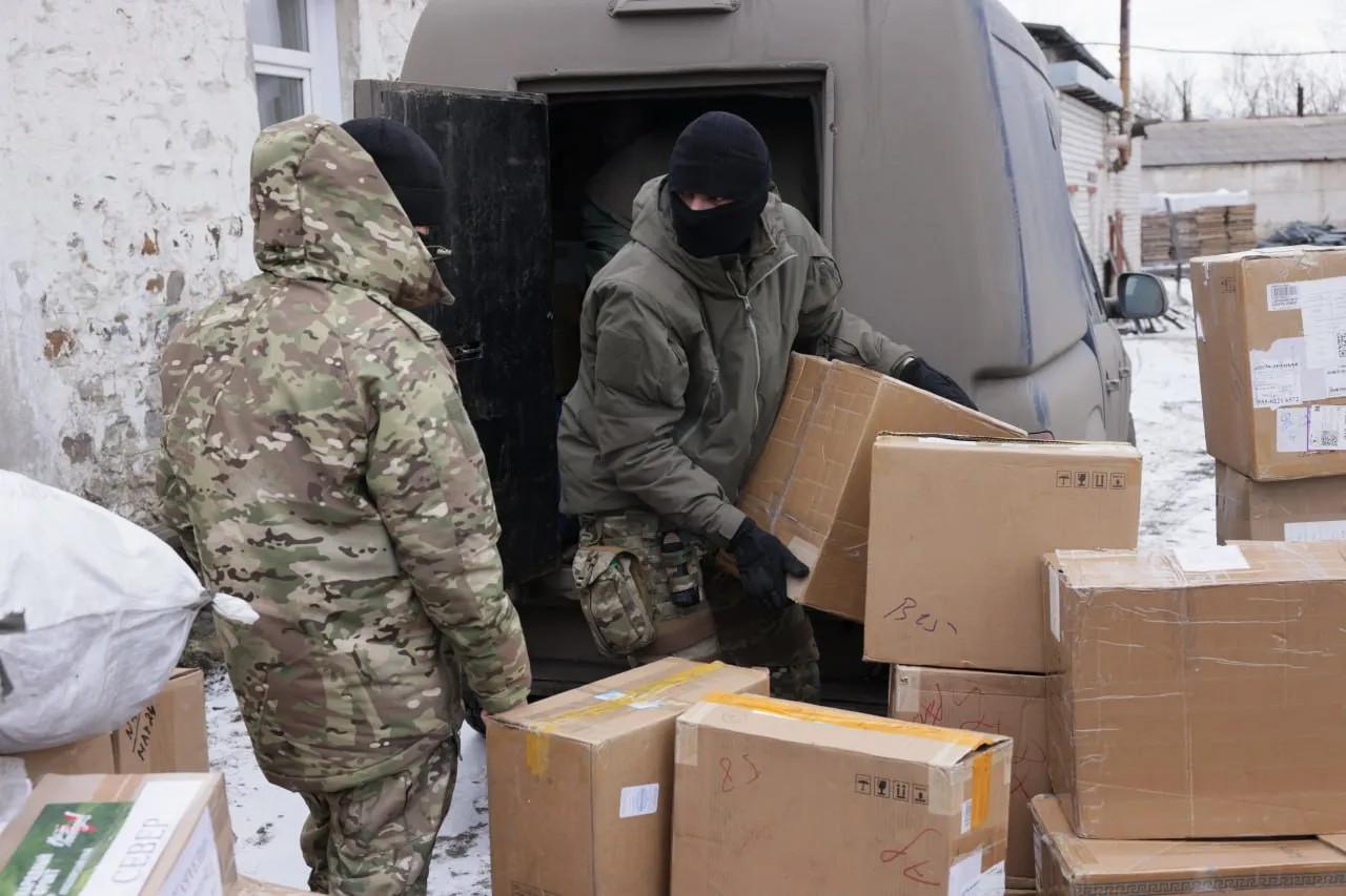 Бойцы-сибиряки загружают в машину коробки с гуманитарной помощью от нашего региона.