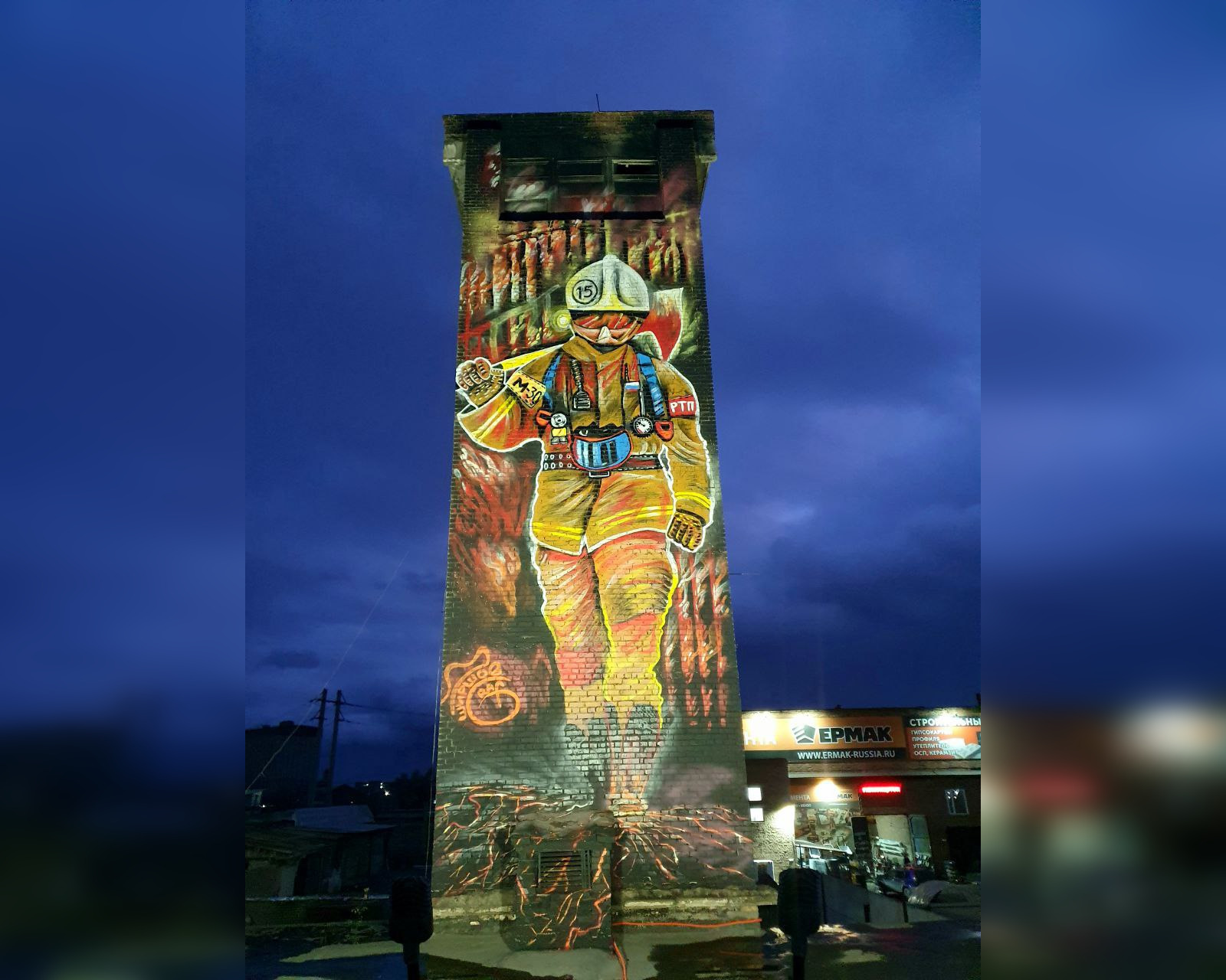 В Ачинске учебную башню пожарной части украсили муралом с подсветкой