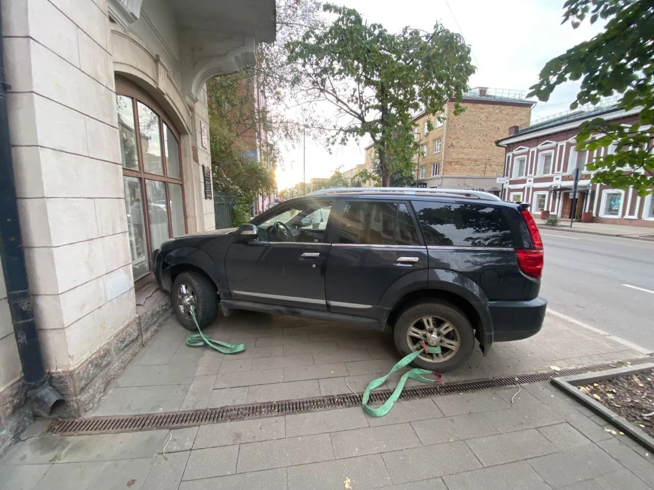 В Красноярске перевозимый в грузовике автомобиль выпал на проезжую часть и врезался в здание